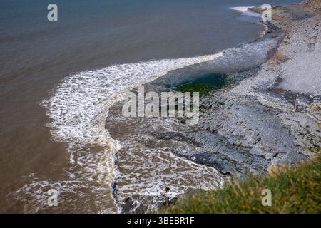Onde di marea a Monknash Beach sulla Glamorgan Heritage Coast nel Galles del Sud nel Regno Unito Foto Stock