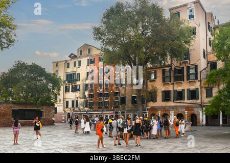 Turisti a campo del Ghetto nuovo con la Casa Chabad e la galleria del Banco Rosso, il più antico pedone ebraico, sullo sfondo, Venezia Foto Stock