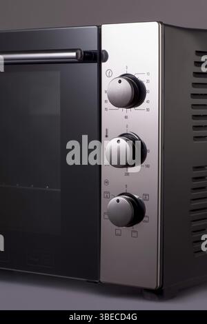 Termostato e maniglie su un moderno forno a microonde. attrezzature da cucina Foto Stock