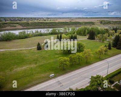Grande campo aperto con un fiume che lo attraversa. Il cielo è nuvoloso e l'erba è verde Foto Stock