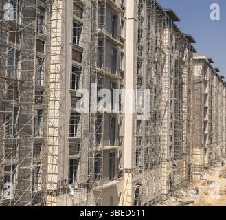 Lavori di rifinitura in marmo sulla facciata di un alto edificio Foto Stock