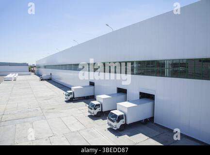 Facciata di un edificio industriale e di un magazzino con vagoni merci in lunghezza Foto Stock