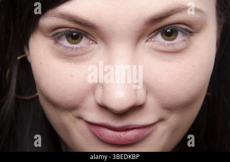 Ritratto di un bel venti-anno-vecchia ragazza, brunette. Un sorridente bambina guarda in un frame Foto Stock