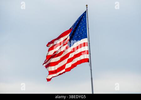 American Fork, UT - 28 maggio 2025: Una bandiera americana ondeggia lungo l'Interstate 15 a American Fork, simboleggiando il patriottismo e l'orgoglio nazionale. Foto Stock