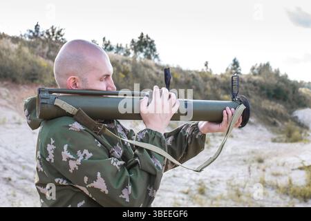 mosca, russia, 26.08.2016 Un uomo mimetico ha in mano una pistola. Sembra serio e concentrato. Concetto di pericolo e tensione, mentre l'uomo si sta preparando Foto Stock
