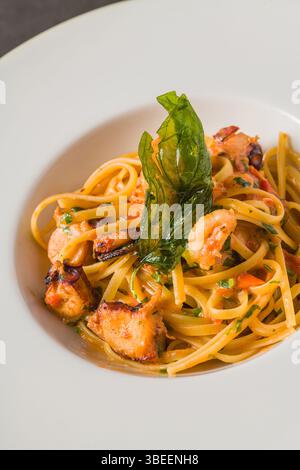 Pasta di linguine con gamberi e frutti di mare in salsa di pomodoro e aglio Foto Stock