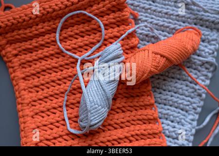 Tessitura Paracord. Cavo luminoso. Fune di cotone grossolano per borse e cesti. Cose a maglia. Materiale per macrame. Fili nelle mani. Palmo femminile. Foto Stock