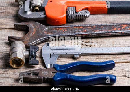Ampia gamma di utensili idraulici su fondo in legno. Primo piano Foto Stock