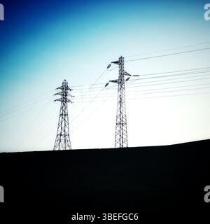 Due torri di potenza si alzano verso l'alto, con una silhouette che si estende contro un cielo crepuscolo in transizione. Francia Foto Stock