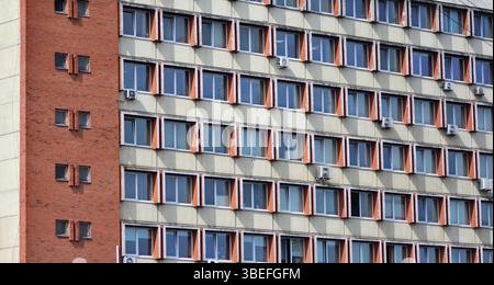 Facciata di un vecchio edificio residenziale sovietico, con finestre a ripetizione, molte dotate di aria condizionata. Foto Stock