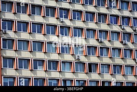 Facciata di un vecchio edificio residenziale sovietico, con finestre a ripetizione, molte dotate di aria condizionata. Foto Stock