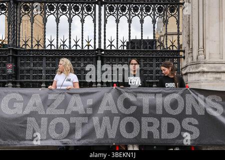Londra, Regno Unito. 29 maggio 2025. Manifestanti e attivisti di diverse organizzazioni, tra cui Choose Love, International Jewish Antizionist Network e Football Against Apartheid raduno con cartelli e bandiere fuori dal Parlamento oggi a Westminster. Un manifestante Choose Love legge i nomi dei bambini palestinesi uccisi nel conflitto. Crediti: Imageplotter/Alamy Live News Foto Stock