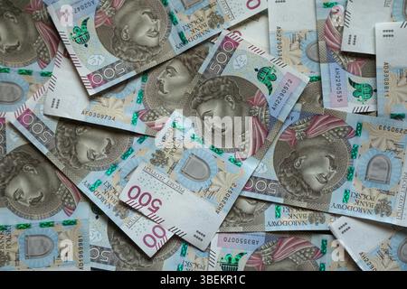 Banconote sparse di 500 zloty con il ritratto reale, formando uno sfondo dinamico. Una miscela di arte e finanza - primo piano della valuta polacca, perfec Foto Stock