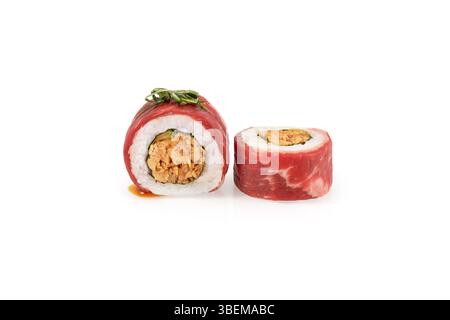 Due panini di sushi uramaki, uno tagliato a metà, che mostrano il ripieno piccante e il sottile involucro di manzo, isolati su bianco Foto Stock