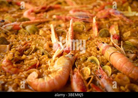 Dettaglio di una tipica paella di pesce spagnola con riso e aragosta, gamberi e vongole Foto Stock