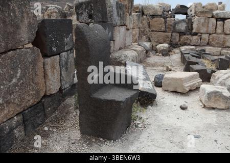 Sussita, Hippos, sedia in pietra basaltica tra le rovine di una stanza nella Chiesa del Nord-Ovest, le sue pareti sono costruite con pietra calcarea e basalto. Foto Stock