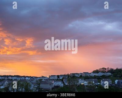 Il cielo risplende di vivaci tonalità arancio e rosa sopra le case in un quartiere residenziale vicino a Pittsburgh durante l'alba. Foto Stock