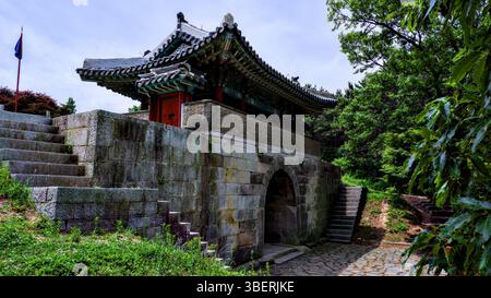 Tradizionale architettura coreana della porta Est della Fortezza di Geumjeong a Busan, Corea del Sud. Una storica struttura in pietra con tetto piastrellato, circondata Foto Stock