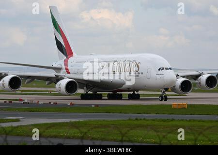 Emirates A380 a terra all'aeroporto di Manchester (MAN), Regno Unito. Aereo completamente visibile, leggera recinzione perimetrale sul fondo. Preso il 23.04.2025 Foto Stock