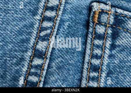 Tessuto macro di jeans di cotone blu. Cuciture tascabili e filettate. Foto Stock