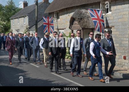 Giornata annuale del Club Walk Day della Long Sutton Friendly Society. Membri, è una società solo maschile che cammina in processione intorno al villaggio fermandosi in varie grandi case per rinfreschi. Cottage del villaggio con bandiere Union Jack. Long Sutton, Somerset, Inghilterra 2019 UK 2010s HOMER SYKES Foto Stock