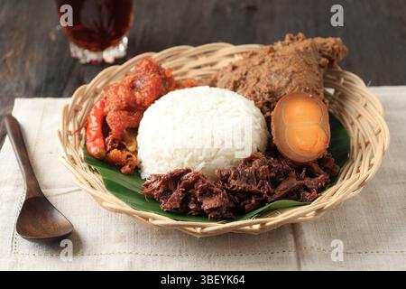 Un piatto di Gudeg Komplit, piatto tipico della regione speciale di Yogyakarta. A base di jackfruit giovane cucinato con latte di cocco. Foto Stock