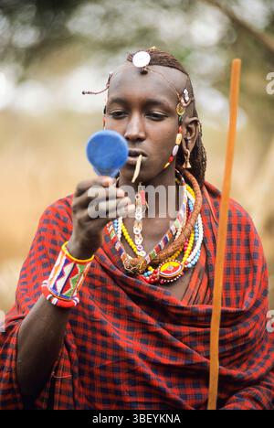 Giovane guerriero Maasai che indossa il cordone, le collane, i pendenti per le orecchie, il cerchio per la testa, Kenya, Africa orientale Foto Stock