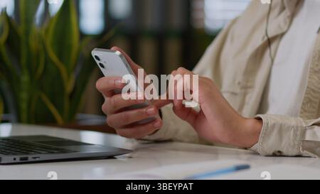 Primo piano di mani maschili che scrivono un telefono cellulare uomo d'affari irriconoscibile uomo afroamericano lavoratore d'affari che utilizza lo smartphone al tavolo in ufficio online Foto Stock