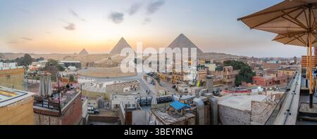 Vista delle piramidi di Giza dalla terrazza sul tetto al tramonto, il Cairo, l'Egitto, l'Africa Foto Stock
