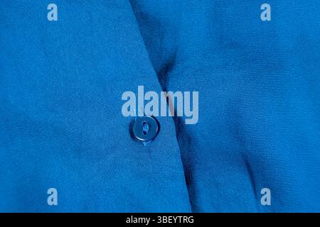 Primo piano con bottone su una camicia in poliestere. Foto Stock