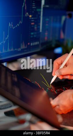filmati che mostrano la moderna interfaccia di scambio basata su blockchain grafici dei prezzi delle criptovalute più display. La persona analizza le tendenze di mercato utilizzando lo stilo d Foto Stock