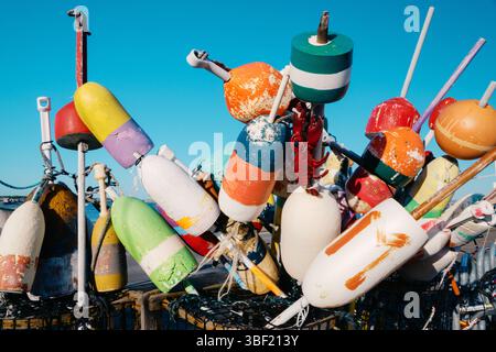 Boe di aragosta colorate che poggiano sul molo sotto il cielo blu Foto Stock