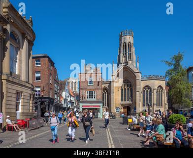 Negozi su St Helens Square che guardano verso St Helen Stonegate Church, York, North Yorkshire, Inghilterra, Regno Unito Foto Stock