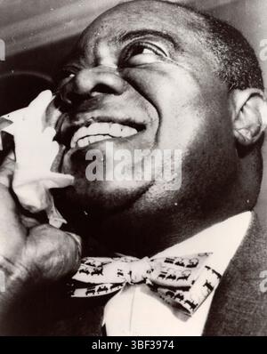 Louis Daniel Armstrong (4 agosto 1901 – 6 luglio 1971), soprannominato "Satchmo", è stato un trombettista e cantante statunitense. Fu tra le figure più influenti del jazz. Alla fine della sua vita, la sua influenza si era diffusa nella musica popolare. È stato uno dei primi artisti afroamericani a raggiungere una grande popolarità tra il pubblico bianco e internazionale. Armstrong raramente discusse pubblicamente di questioni razziali, a volte con sgomento degli altri neri, ma prese una posizione ben pubblicizzata per la desegregazione nella crisi di Little Rock. Foto Stock