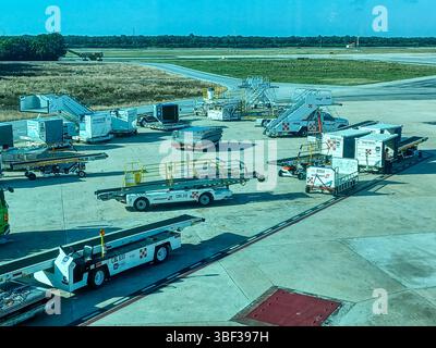 Cancun, Quintana Roo, Messico – 26 novembre 2024: Attrezzature di supporto a terra e container di carico sono pronti sull'asfalto dell'aeroporto internazionale di Cancun Foto Stock
