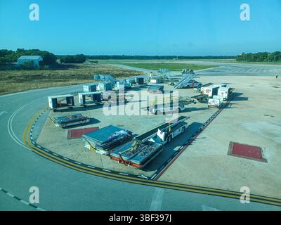 Cancun, Quintana Roo, Messico – 26 novembre 2024: Attrezzature di supporto a terra e container di carico sono pronti sull'asfalto dell'aeroporto internazionale di Cancun Foto Stock