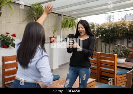 Due amici scattano foto sulla terrazza di legno Foto Stock