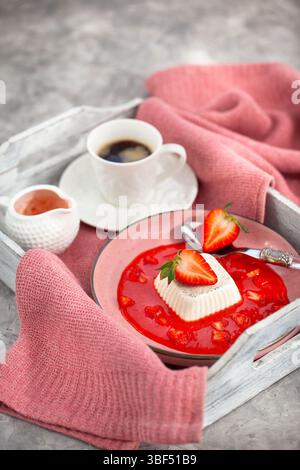 Delizioso dessert italiano panna cotta con salsa di fragole e frutti di bosco freschi Foto Stock