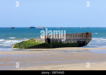 I resti di Mulberry Harbour B (Port Winston) utilizzati il D-Day per portare truppe, rifornimenti e veicoli ad Arromanches-les-Bains (Calvados), in Francia Foto Stock