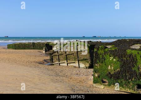 I resti di Mulberry Harbour B (Port Winston) utilizzati il D-Day per portare truppe, rifornimenti e veicoli ad Arromanches-les-Bains (Calvados), in Francia Foto Stock