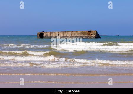 I resti di Mulberry Harbour B (Port Winston) utilizzati il D-Day per portare truppe, rifornimenti e veicoli ad Arromanches-les-Bains (Calvados), in Francia Foto Stock
