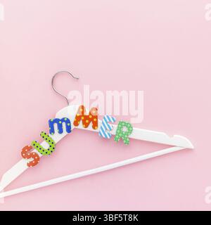 Creative vista superiore piatto bianco laici i portabiti in legno estate testo rosa pastello sfondo spazio copia stile minimalista. Il modello femminile di moda blog sociale Foto Stock