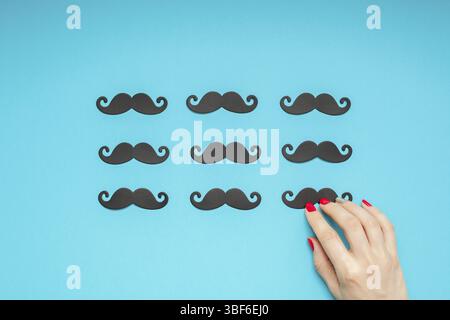 Creative overhead flatlay vista superiore retro nero elegante carta Photo Booth puntelli baffi turchese mano femmina copia di sfondo spazio. Gli uomini salute awar Foto Stock