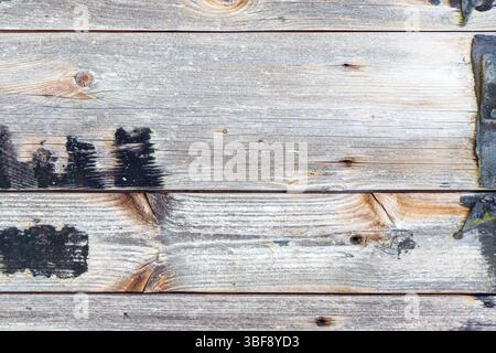 Immagine sopra la testa di tavole di legno grigie con macchie nere e ferramenta sul bordo destro. Foto Stock
