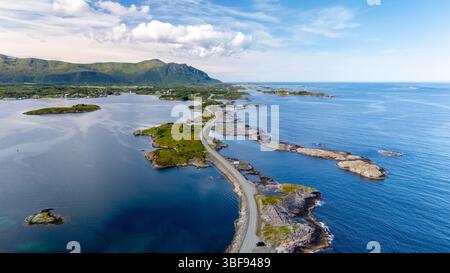 Esplora un paesaggio costiero mozzafiato in Norvegia, dove le acque cristalline incontrano le isole aspre. La vista panoramica cattura la tranquillità lungo la costa sotto un cielo luminoso, Atlantic Ocean Road, Norvegia Foto Stock