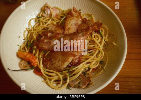 Spaghetti croccanti di pancetta con peperoncino ed erbe aromatiche Foto Stock