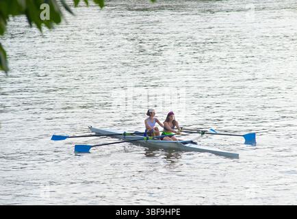 Canottaggio in tandem sul po, Torino. Il canottaggio è l'atto di spingere una moto d'acqua alimentata da esseri umani utilizzando i movimenti volanti dei remi per spostare l'acqua e generare una propulsione reazionaria. Foto Stock