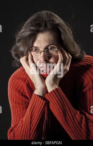 Uomo con capelli di tronco in maglione rosso e occhiali Foto Stock