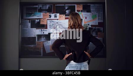 Il detective privato che esamina le prove nell'ufficio investigativo Foto Stock