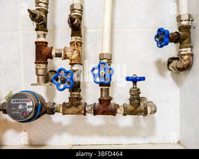 i vecchi rubinetti di alimentazione dell'acqua e il flussometro dell'acqua si chiudono a casa Foto Stock
